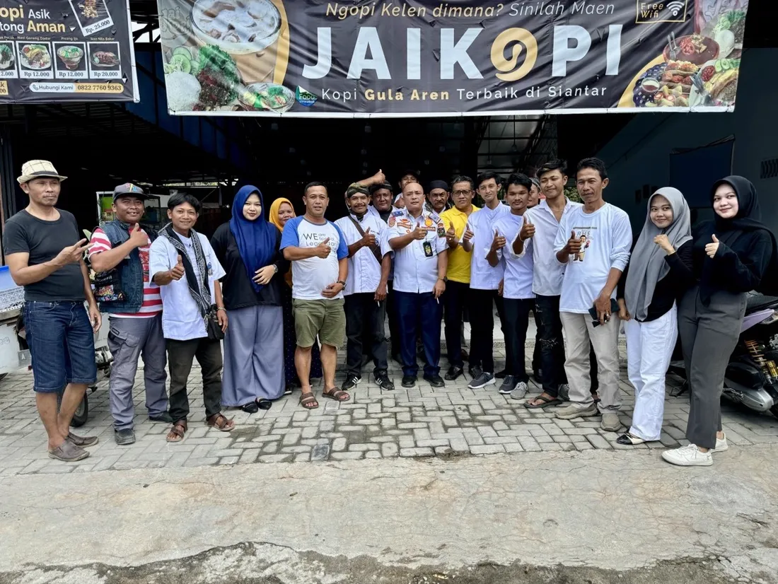 Rombongan komunitas berfoto di depan spanduk Jaikopi