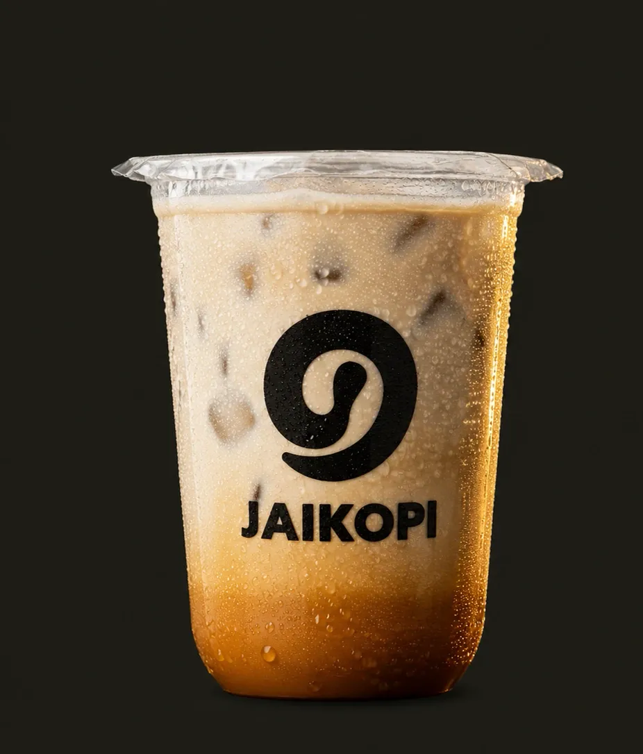Kopi Suren dingin di gelas Jaikopi, susu creamy di atas gula aren